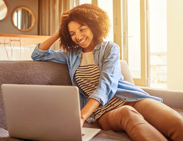 cropped-cliente-itau-sorridente-no-sofa-mexendo-no-computador-3.jpg